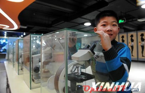 一位小朋友在通過高倍率顯微鏡觀看各種色譜的變化。